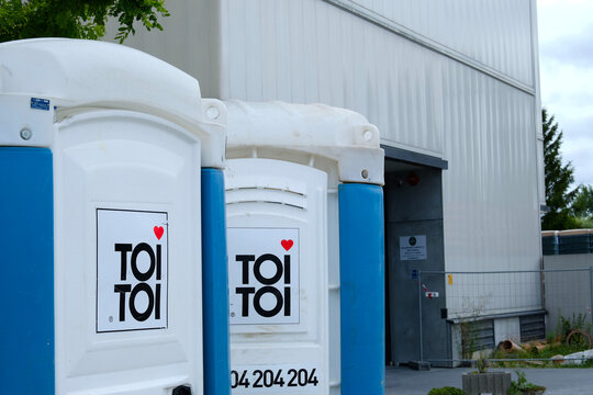 Two blue portable chemical toilets owned by "ToiToi' company in Poland