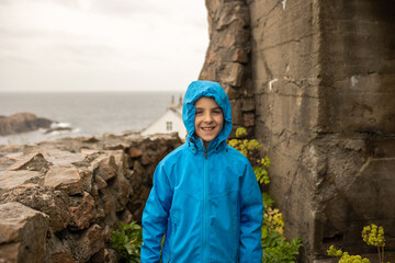 Family visiting the Lindesnes Fyr Lighthouse in Norway on a rainy cold day - obrazy, fototapety, plakaty