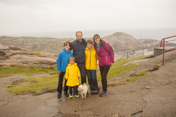 Family visiting the Lindesnes Fyr Lighthouse in Norway on a rainy cold day - obrazy, fototapety, plakaty