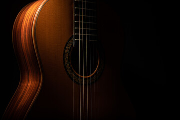 Classical guitar close up, dramatically lit on a black background with copy space - Powered by Adobe