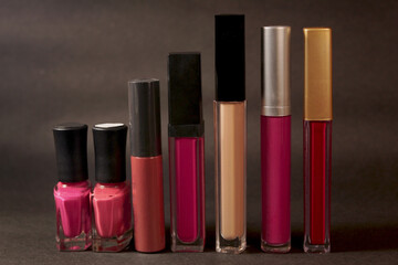 lipsticks and nail polish on greyish bokeh background