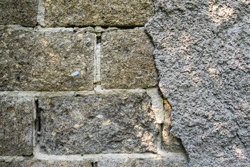 old cinder block wall with destroyed cement plaster