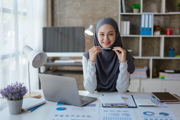 Muslim business woman working on laptop with happy and smile face on office spec.