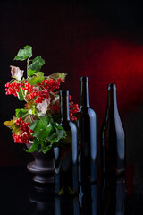Still life with glass bottles and red viburnum
