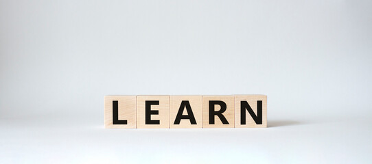 Learn symbol. Wooden cubes with word Learn. Beautiful white background. Learn concept. Copy space.