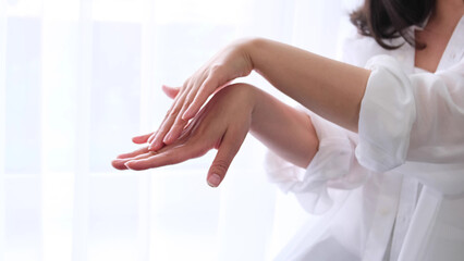 beauty and wellness products. lady runs gently over her hand, enjoying the softness of the skin after using the cream. the concept of self-care, self-love.