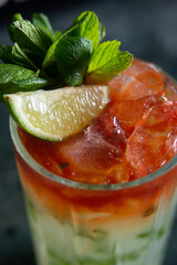cocktail with lime and herbs on a marble table of a bar