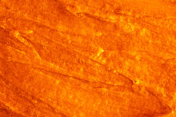 Smears of liquid yellow gel texture background. To grease with oil gold paint with pearly shine. Cream-scrub to cleanse the skin of the face and body. Spa treatments, skin care.