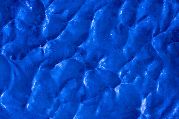 Smears of liquid blue gel texture background. Smeared oil paint with pearly shine. Cream scrub to cleanse the skin of the face and body. Spa treatments, skin care.