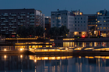 Fototapeta na wymiar Stockholm, Sweden Illuminated swimming platforms at night in the Liljeholmskajen district.