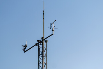 Communication antenna pole stands against clear blue sky. High antenna provides connection among...