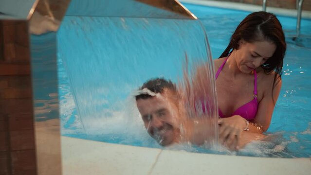 Young couple enjoys a vacation by swimming in an indoor pool at a hotel