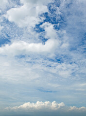 Blue sky and cumulus clouds. Vertical photo.