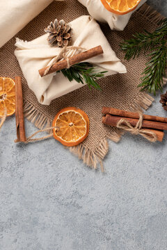 Zero waste christmas concept. Packed in natural fabric gifts and decorations from natural materials on gray table, top view, copy space