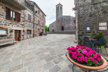 Italian medieval village details, historical stone square, ancient church abbey, old city stone buildings architecture. Radicofani, Tuscany, Italy.. Radicofani, Tuscany, Italy.