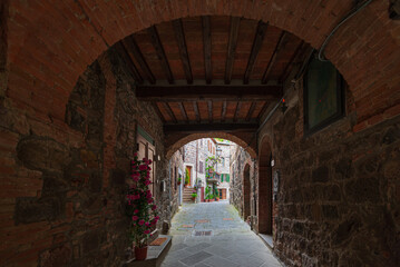 Italian medieval village details, historical stone arch, ancient gate, old city stone buildings architecture. Radicofani, Tuscany, Italy.