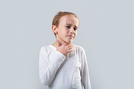 Young boy feels that his throat is pain. Ill little boy with sore throat. Ill child with sore throat. Sore throats in a child. Child has a sore throats. Signs of a cold in children