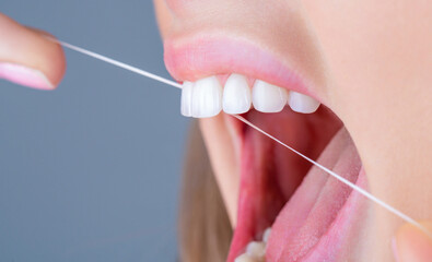 Teeths Flossing. Oral hygiene and health care. Smiling women use dental floss white healthy teeth. Dental flush - woman flossing teeth. Dental floss. Taking care of teeth. Healthy teeth concept