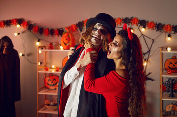 Adult friends dressed in costumes of evil characters having fun and fooling around at spooky...