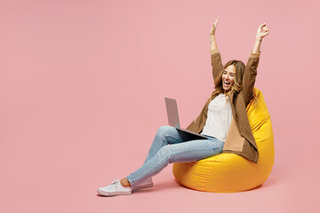 Full body young fun employee business woman she wear casual brown classic jacket sit in bag chair...