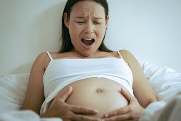 A pregnant woman having stomach cramps and aches. Contractions.