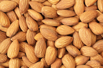 Pile of big raw peeled almonds situated arbitrarily. View from above. Closeup