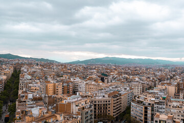 Fototapeta na wymiar Top view of Barcelona city with apartment buildings and mountains in the background