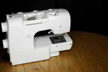 white sewing machine on a wooden table