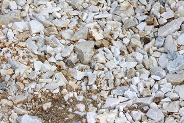 grupo de pedras brancas e cinzas no chão, muitas pedras no chão, pedras esbranquiçadas no chão, pedras cinzentas