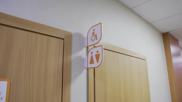 4K. A sign for a disabled, male and female toilet near the door in an office setting.