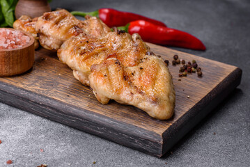 Baked chicken wings with sesame seeds and sauce on a wooden cutting board