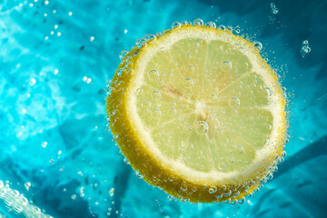 fresh abstract background with yellow lemon in blue clear water
