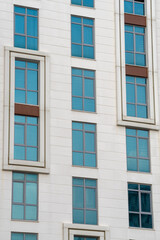 Fototapeta na wymiar Modern high-rise building. A number of identical windows.