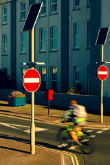 Blurred bicyclist passing by no entry sign