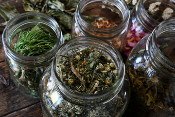 A top view image of a glass jar filled with dried dandelion flowers used in making homemade herbal medicine. 