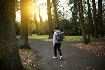 A man walks along a path among the park