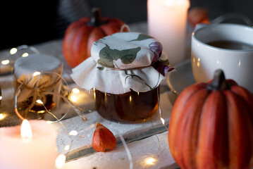 jam jar on autumn decor with pumpkin and cup of tea. White background