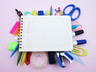    open notebook amid colorful school supplies  