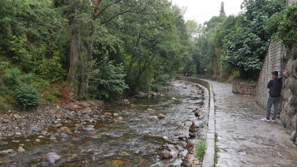 Promenade au bord de la rivière Quivesa, dans la commune de Potes, avec ses pierres, ses monuments historiques, son cours d'eau et sa faune, sous un temps nuageux, pluvieux et gris
