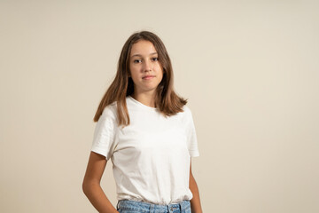 Portrait of a young European woman with healthy clean skin and brown eyes wearing a casual top looking at the camera with a serious expression. Spanish female model with loose hair.