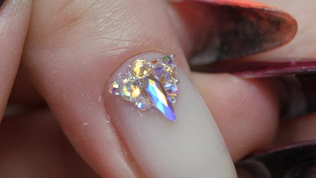 Applying a three-dimensional pattern with rhinestones and broths on the nail.