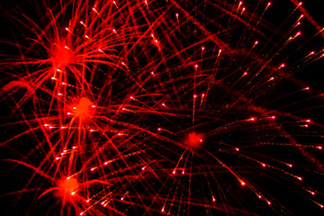 Bright, beautiful red fireworks in the night sky.