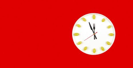 Clock made of plate and grapes on red background. Latin American and Spanish New Year tradition to...