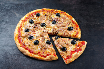 Traditionelle italienische Pizza al tonno mit Thunfisch, Zwiebel und Oliven serviert als close-up auf einem alten rustikalen Board mit Textfreiraum 