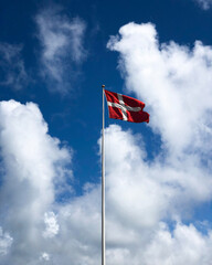 Denmark Flag with a Blue Cloudy Sky