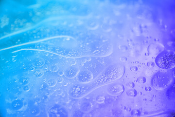 blue and purple abstract background formed by oil drops on water