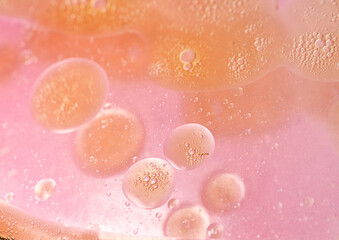 abstract pink and orange background formed by oil drops on water