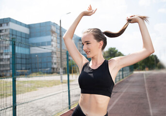 Portrait of a young female athlete in motion. Outdoor sports activities.