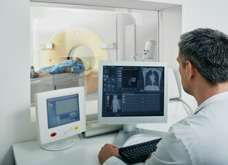 Doctor radiologist running CT scan for patient's body lungs from control room. Computed Tomography - 524353960