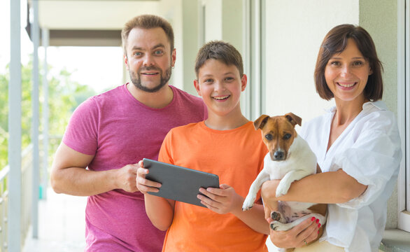 Portrait Of A Happy Joyful Family. Dad, Mom And Son Use A Tablet. With Cheerful Joyful Emotion.internet Shopping Online Banking Video Call Technology Concept